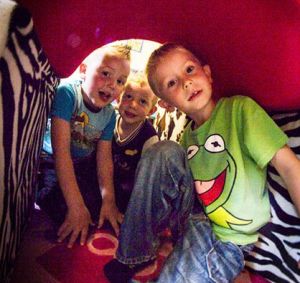 Barn som leker i en tunnel inomhus. Foto.