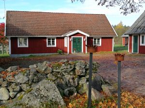 Hus med stengärdsgård. Foto.