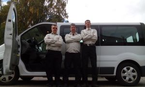 Tre personer står framför en minibuss. Foto.