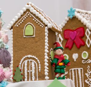 Ett pepparkakshus med en liten tomte utanför.