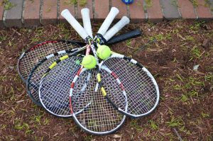 Tennisracket som ligger på marken.