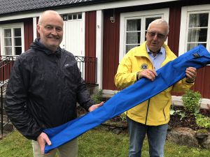 Uno Johansson från Lions Club Östra Göinge tar emot fanan av Jan Carlson, kultur- och fritidschef i Östra Göinge kommun.