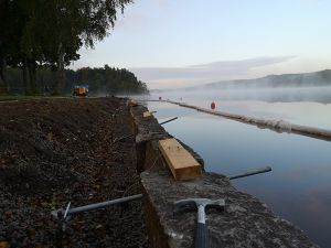 Renovering av Breanäs hamn. En hammare ligger på muren av granitblock.