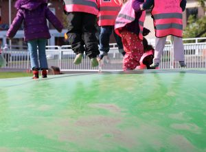 Närbild på barn som hoppar på en av de gröna studsmattorna.