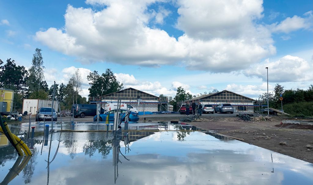 Bild på blötlagd betongplatta i förgrunden. I bakgrunden resta huskroppar på två andra plattor.