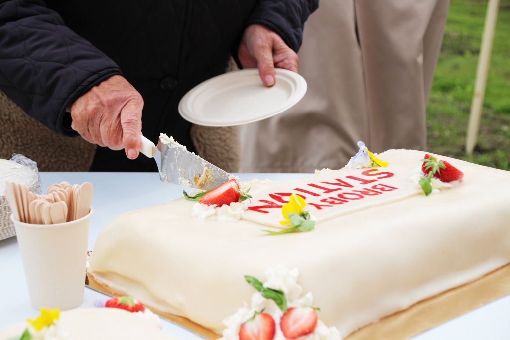 Bild på en tårta och en hand som håller i en tårtspade.